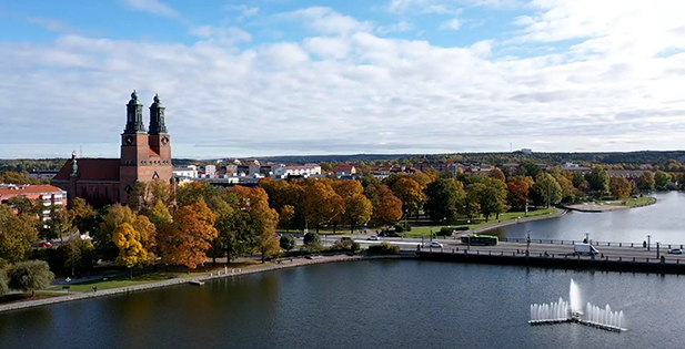 Flygbild över Eskilstuna med ån i förgrunden, kyrka och bostadshus.