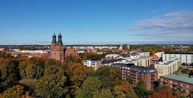 Flygbild över Eskilstuna, med kyrka, träd och bostadshus.